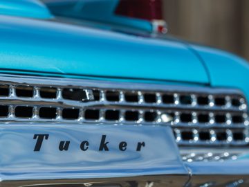 Een close-up van een Tucker-auto met het woord "Tucker" op de grille.
