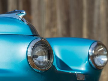 Een close-up van de koplampen van een blauwe Tucker-auto.