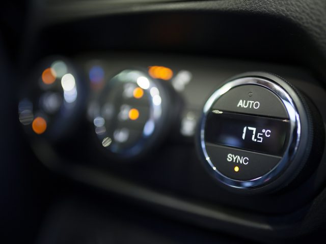 Een close-up van de airconditioningtemperatuurregeling van een auto.