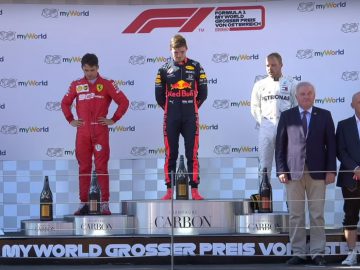 Een groep mensen die op een podium staan, waaronder Max Verstappen.