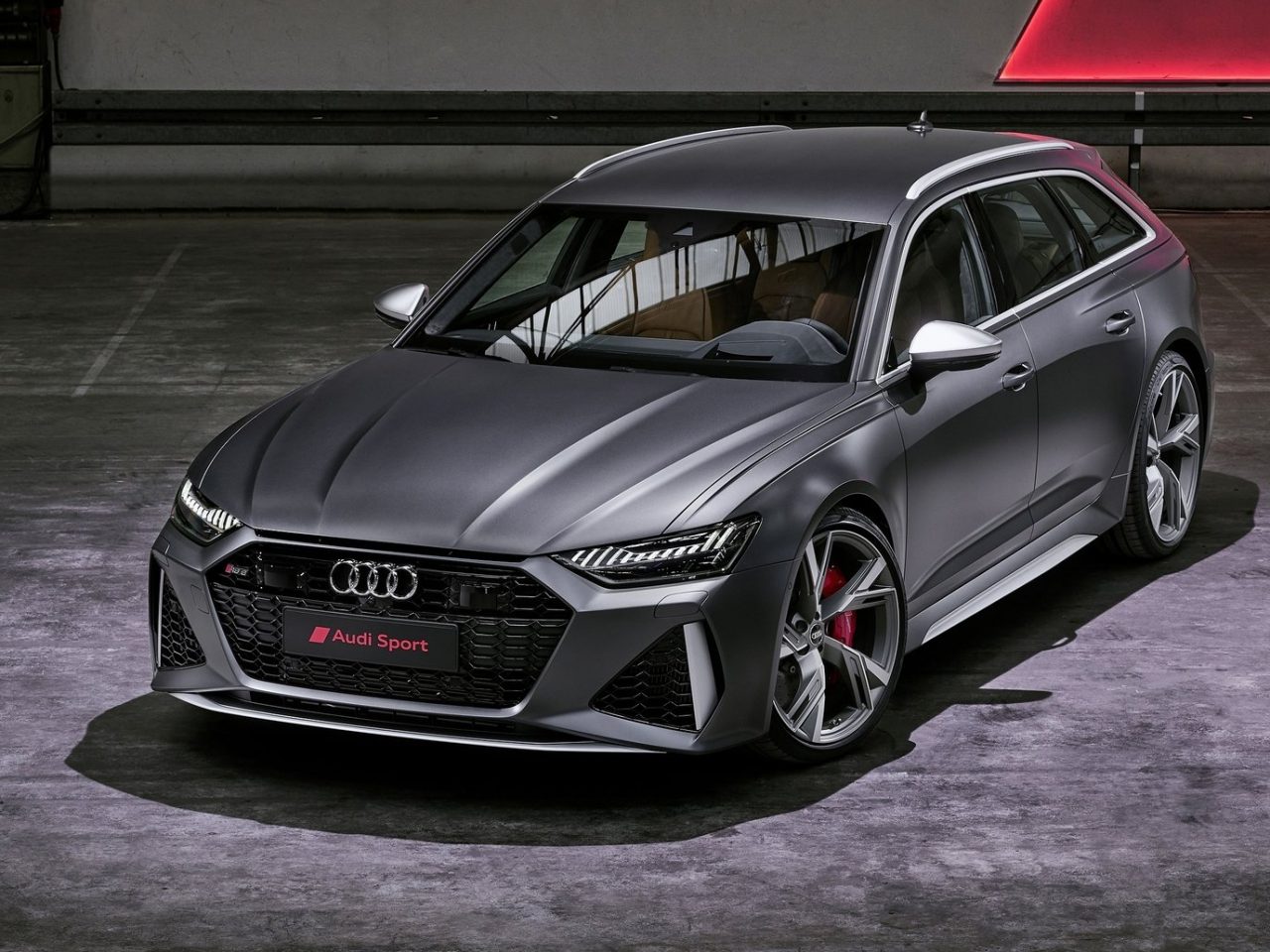 De Audi RS6 Avant wordt getoond in een donkere kamer.