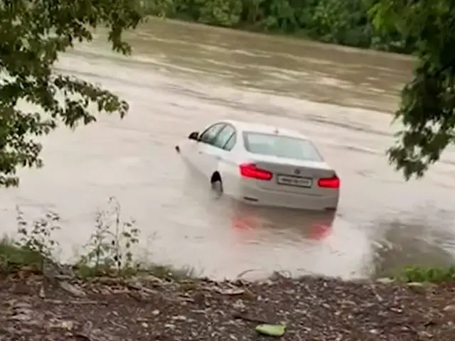 Een witte BMW 3 Serie die door een ondergelopen rivier rijdt.