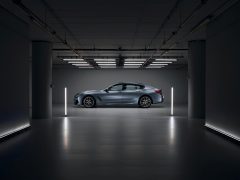 De BMW 8 Serie Gran Coupé staat geparkeerd in een donkere kamer.