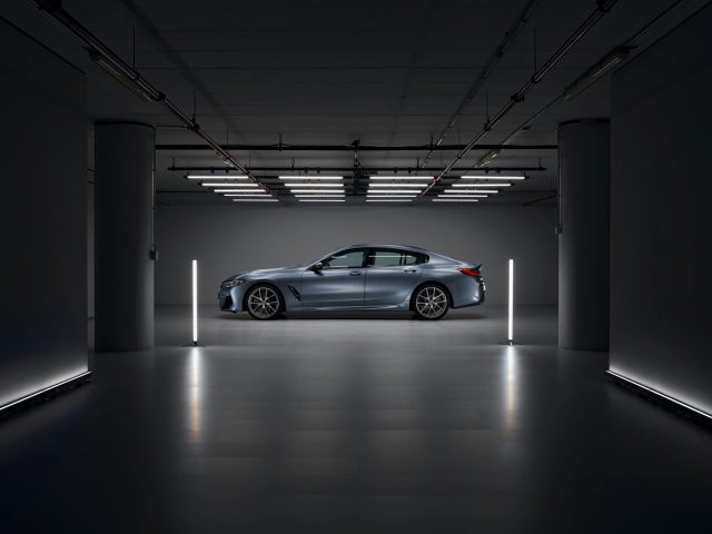 De BMW 8 Serie Gran Coupé staat geparkeerd in een donkere kamer.