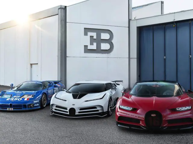 Drie Bugatti Centodieci-supercars geparkeerd voor een gebouw.