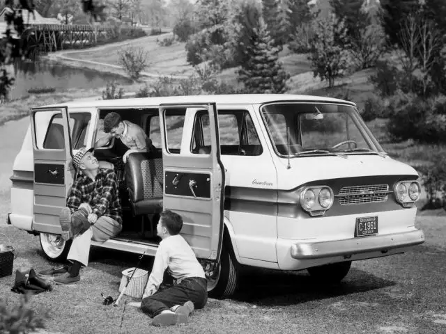 Een zwart-witfoto van een groep mensen die in een Chevrolet Corvair-busje zitten.