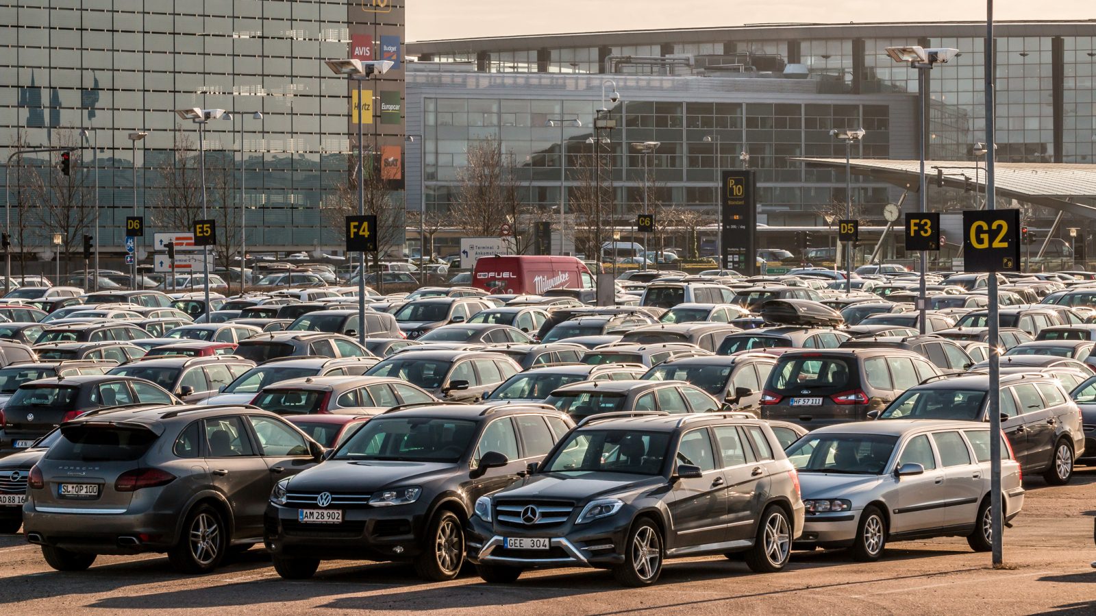 Veel auto's geparkeerd in een parkeerplaats van het vliegveld.