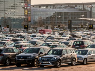 Veel auto's geparkeerd in een parkeerplaats van het vliegveld.