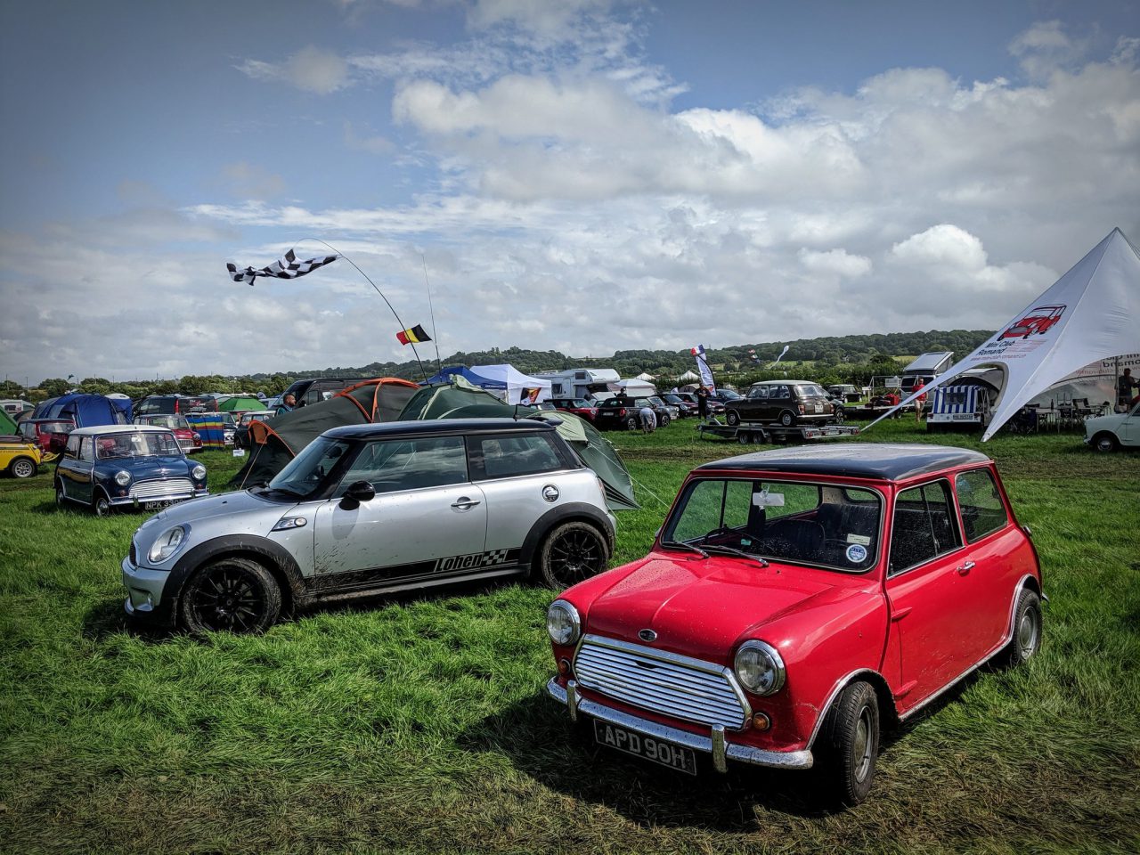 Een rode MINI Cooper S geparkeerd op een grasveld.