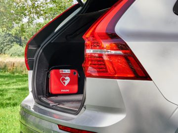 De kofferbak van een auto met daarin een rode AED-doos.
