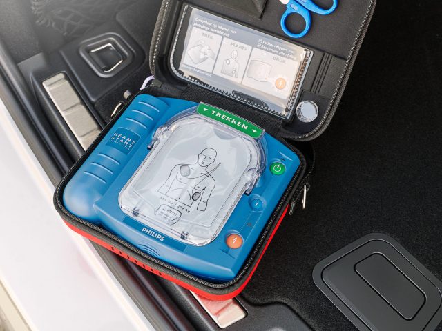 Op het dashboard van een auto zit een AED-apparaat.