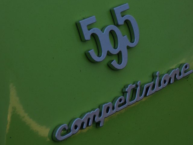 Een close-up van een groene Abarth-auto met een badge erop.