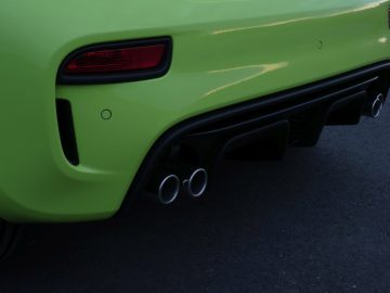 De achterkant van een groene Abarth-sportwagen.