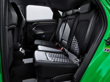 Het interieur van een Audi RS Q3 met zwarte stoelen.