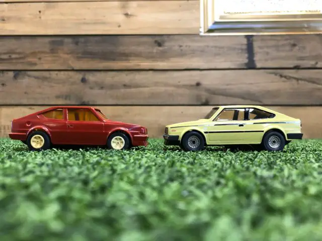 Twee Skoda Rapid Coupé speelgoedauto's op gras naast elkaar.