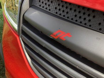 Een close-up van de grille van een rode Opel Vivaro.