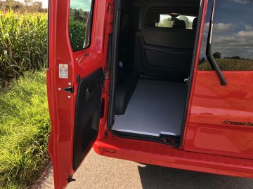De deur van een rood Opel Vivaro-busje met de deur open.