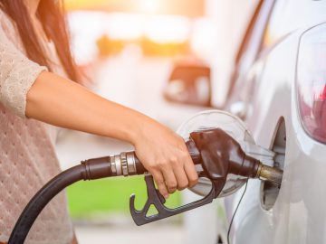 Een vrouw die haar auto vult met brandstof.