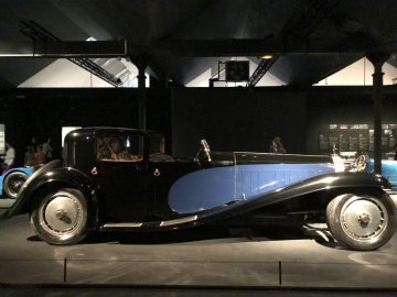 In het museum Cité de l'Automobile staat een zwart-blauwe auto tentoongesteld.