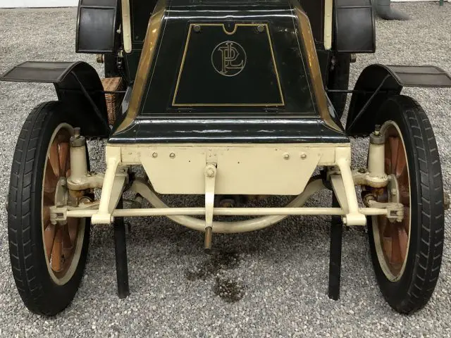 In het museum Cité de l'Automobile wordt een ouderwetse auto tentoongesteld.