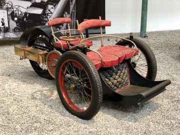 Een ouderwetse auto is te zien in het Cité de l'Automobile-museum.