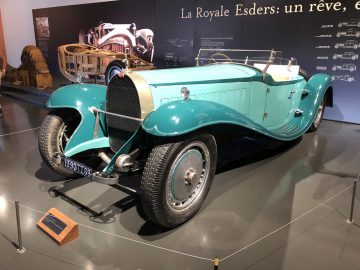 In het museum Cité de l'Automobile staat een blauwe vintage auto tentoongesteld.