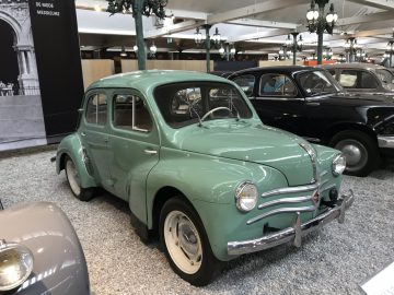 Een oude groene auto is te zien in het Cité de l'Automobile-museum.