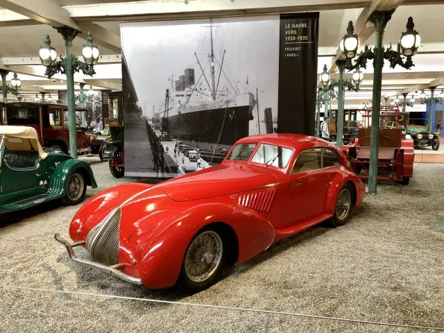 In het museum Cité de l'Automobile staat een rode auto tentoongesteld.