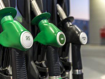 Een groep groene E10-benzinepompen bij een benzinestation.