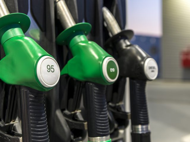 Een groep groene E10-benzinepompen bij een benzinestation.