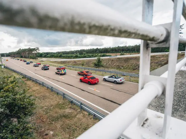 Een groep Ford Mustangs op een snelweg.
