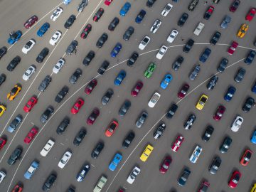 Een luchtfoto van veel Ford Mustangs geparkeerd op een parkeerplaats.