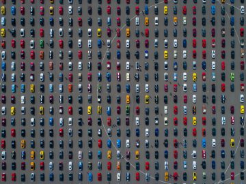 Een luchtfoto van veel Ford Mustang-auto's geparkeerd op een parkeerplaats.
