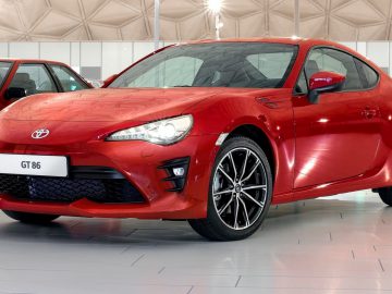 In een showroom staat een Toyota geparkeerd.