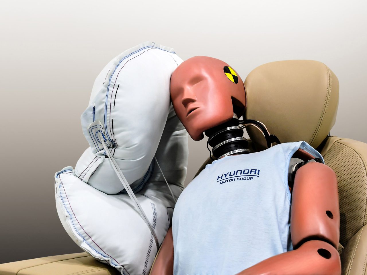 Een mannequin die in een auto zit met een geactiveerde airbag.