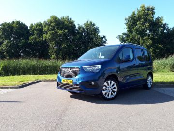 Een blauwe Opel Combo Tour geparkeerd langs de kant van de weg.