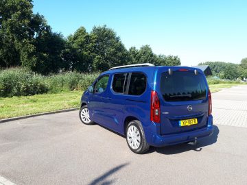 Een blauwe Opel Combo Tour geparkeerd op een parkeerplaats.