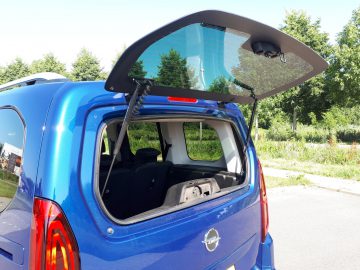 Een blauwe Opel Combo Tour met een deur open.