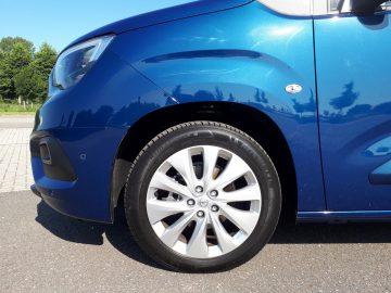 Een blauwe Opel Combo Tour geparkeerd op een parkeerplaats.