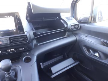 Het interieur van een zwarte Opel Combo Tour-bestelwagen met dashboard en stuur.