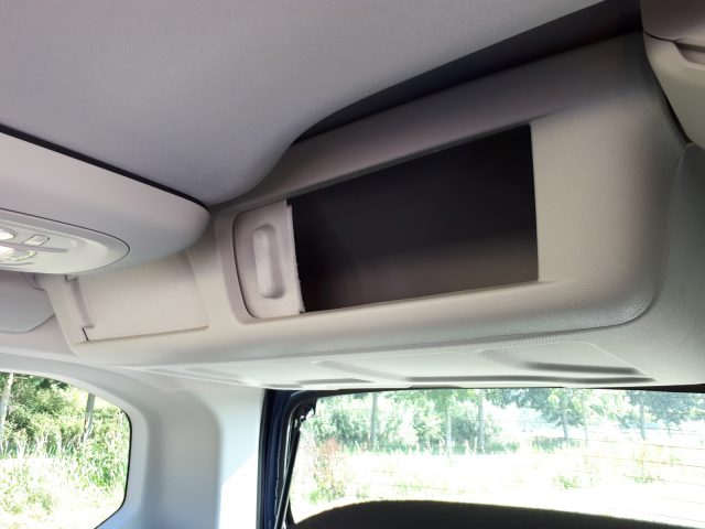 Een blik op het interieur van een Opel Combo Tour met een flatscreen tv.
