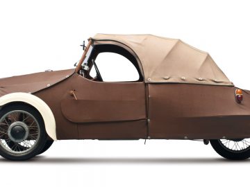 Een kleine bruine auto met een carrosserie erop.