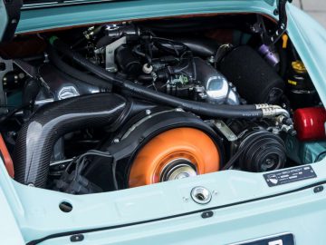 Het motorcompartiment van een blauwe Porsche-sportwagen.