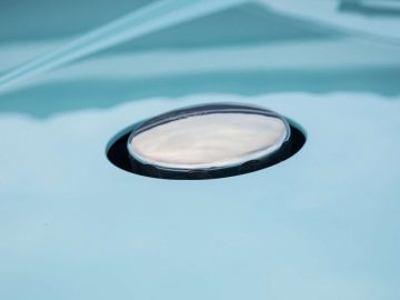 Een close-up van een spiegel op een blauwe Porsche.