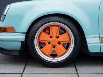 Een Porsche 911 met oranje velgen.