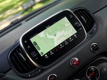 Een Abarth 695 70° Anniversario met een GPS-apparaat op het dashboard.