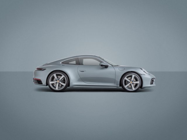 Een Porsche 911-auto in zilver op een grijze achtergrond.