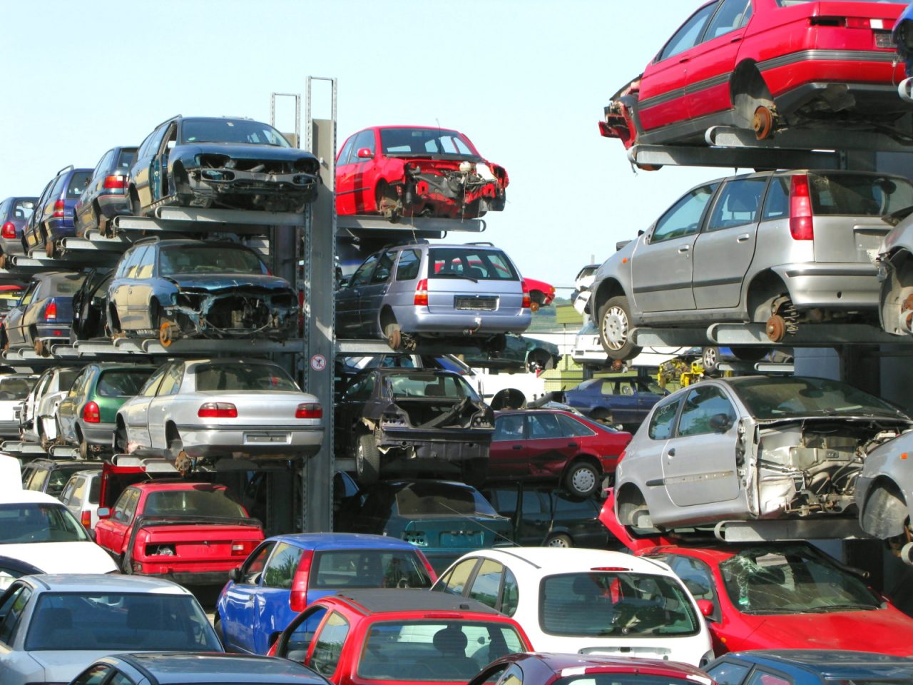 Veel auto's op elkaar gestapeld voor recyclingbijdrage.