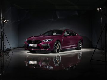 De BMW M8 Gran Coupé wordt getoond in een donkere kamer.