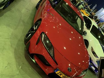 Een rode Toyota Supra geparkeerd in een showroom tijdens de Auto Live 2019.